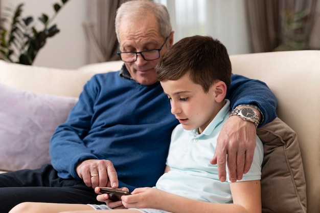 Free photo grandchild and grandfather on the couch relaxing