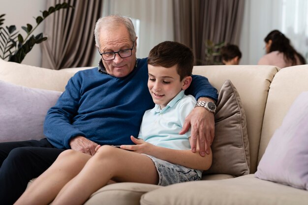 Внук и дедушка отдыхают на диване
