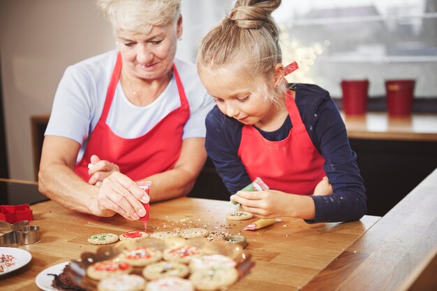 アイシングでクッキーを飾るおばあちゃんと孫