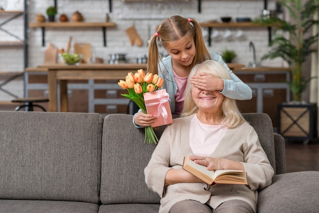 Foto gratuita nipote che copre gli occhi di sua nonna