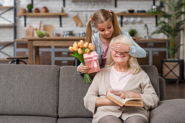 Granddaughter covering her grandmother's eyes