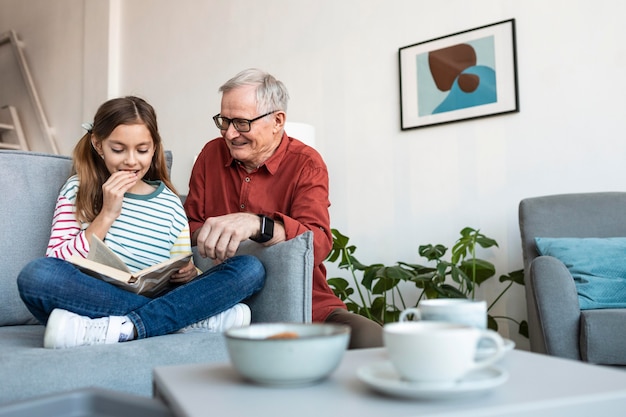 Grandfather and girl reading together