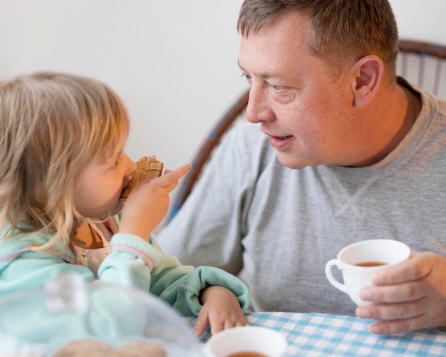 Grandfather and granddaughter having lunch