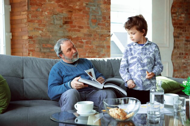 Grandfather and his grandson spending time insulated at home, studying