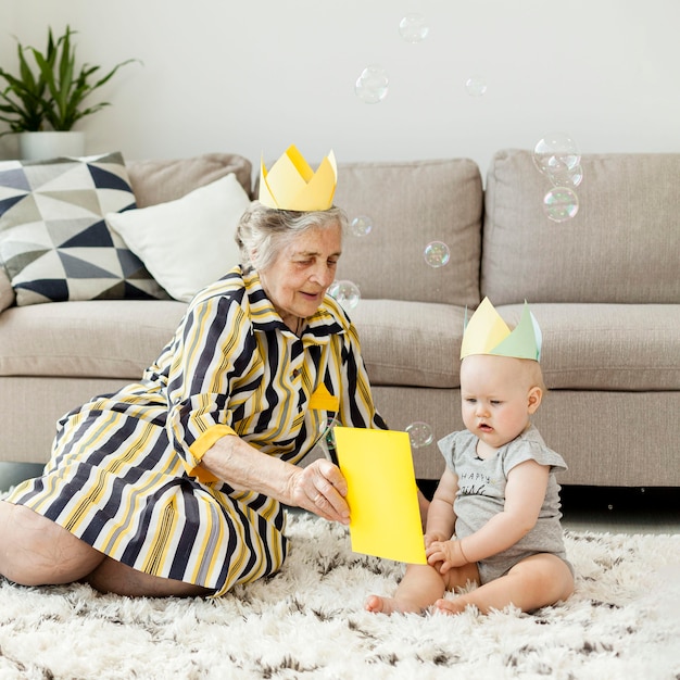 Foto gratuita nonna in abito elegante che gioca con il nipote