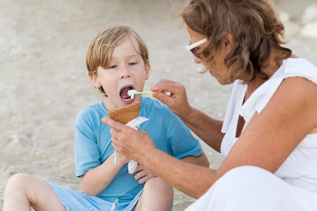 Grandma feeding kid with ice cream