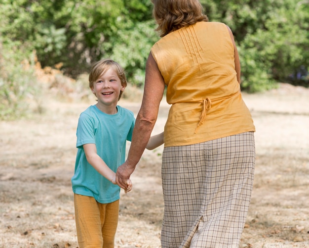 Free photo grandma and kid holding hands outdoors