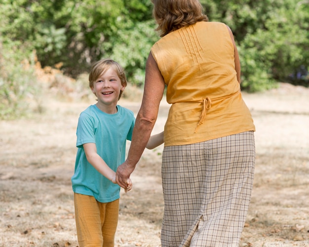 Grandma and kid holding hands outdoors