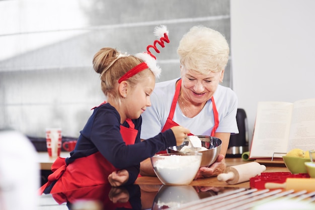 Бесплатное фото Бабушка учит внука печь торт