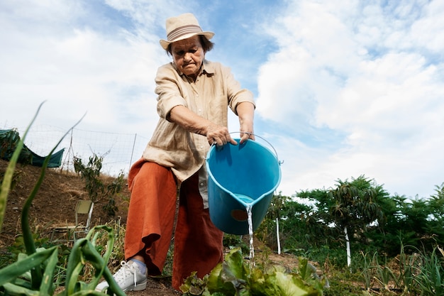 Grandma watering plants in the garden