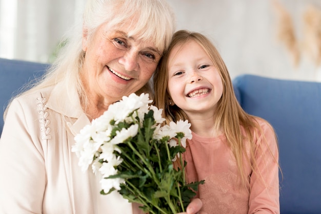 Бесплатное фото Бабушка с цветами от девочки