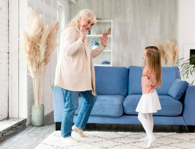 Grandma with girl at home playing