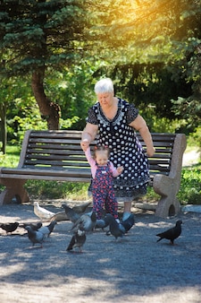 Бабушка и внучка гуляют в парке