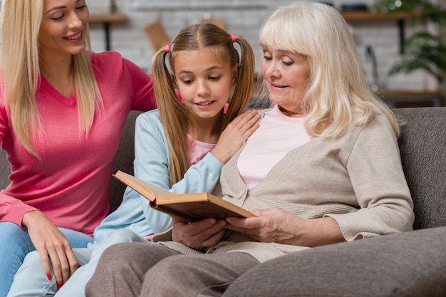 Grandmother and family sitting on a couch and read a book