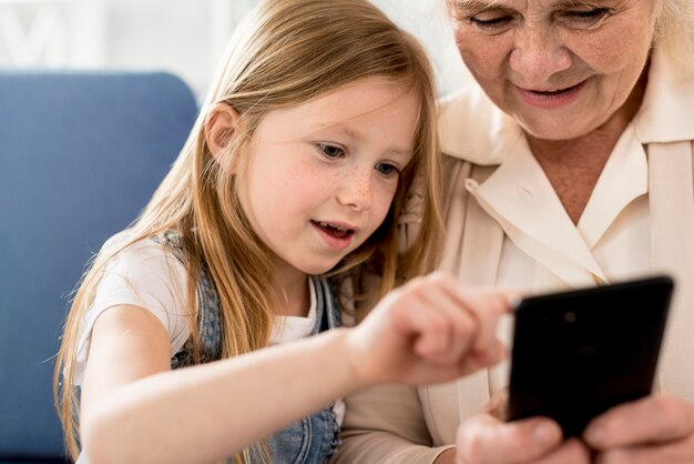 Бабушка и девушка, глядя на мобильный