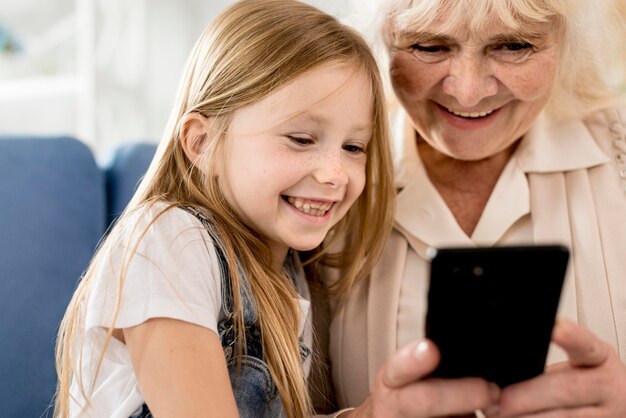 Grandmother and girl looking on mobile