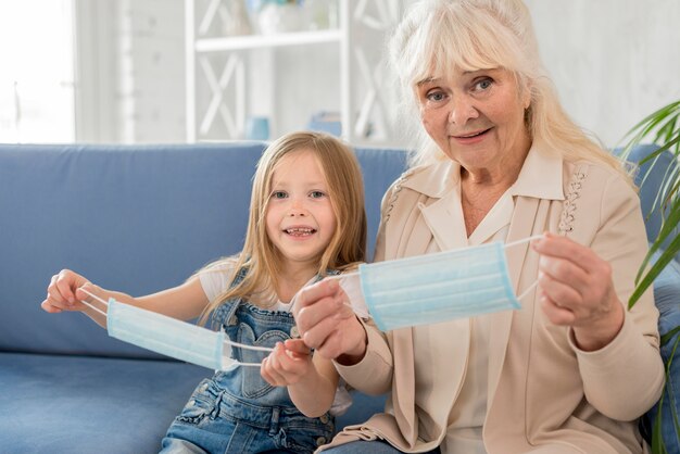 Grandmother and girl putting mask