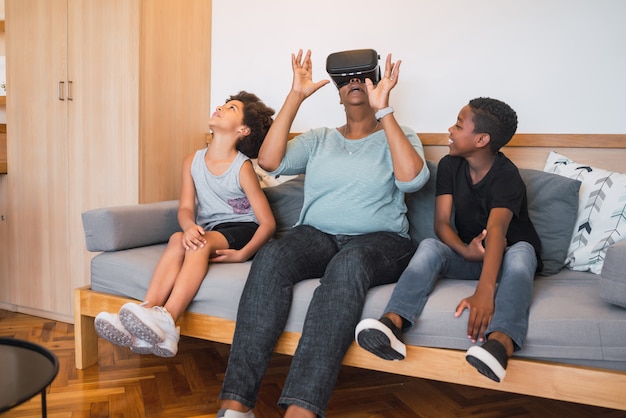 Grandmother and grandchildren playing together with VR glasses.