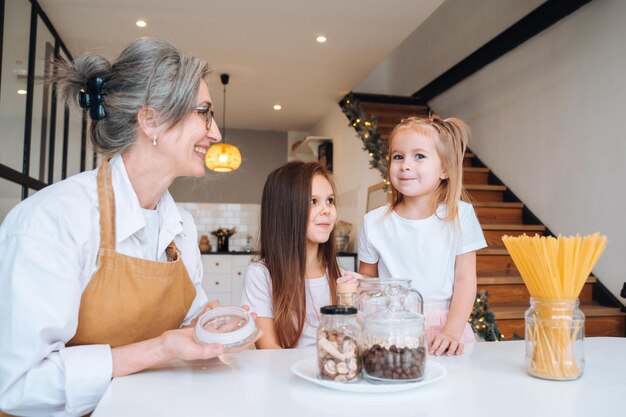 grandmother and granddaughter are cooking on kitchen.