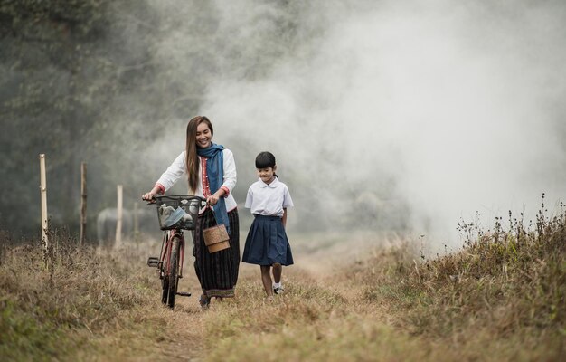 Grandmother and granddaughter are walking in the fields with bicycles.