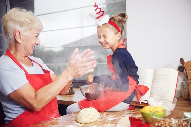 Grandmother and granddaughter enjoying in kitchen 
