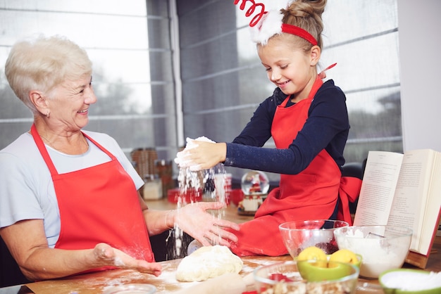 Free photo grandmother and granddaughter enjoying making cookies together