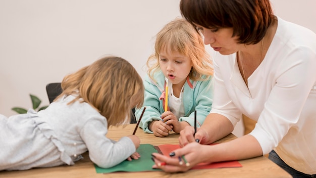 Free photo grandmother and granddaughters playing together