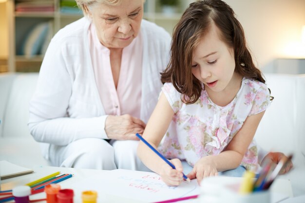 Grandmother helping her granddaughter