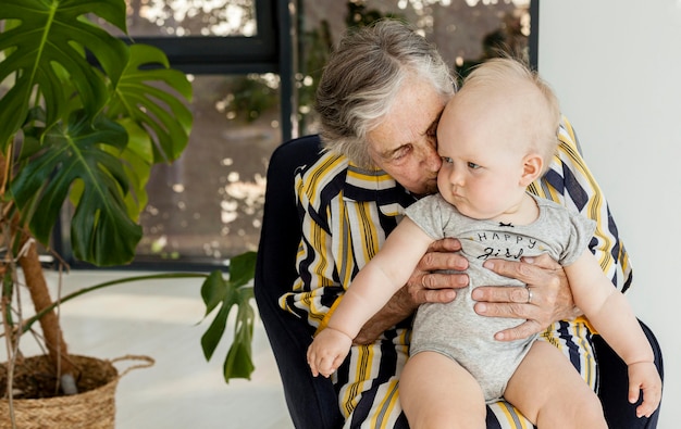 Free photo grandmother holding grandchild at home