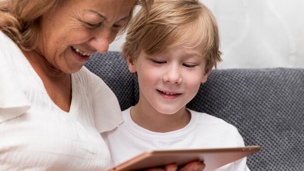 Grandmother and kid with tablet closeup