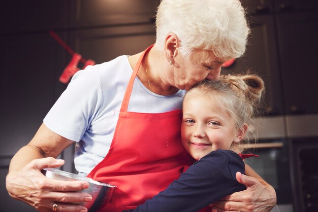 Grandmother kissing and hugging her granddaughter