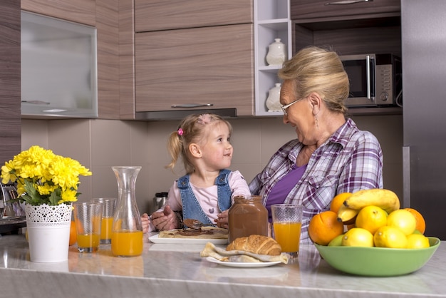 Grandmother playing with her granddaughter in the kitchen