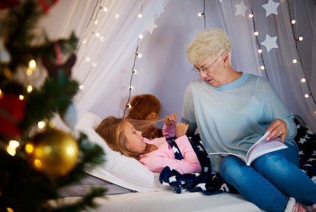 Grandmother reading a storybook to granddaughter