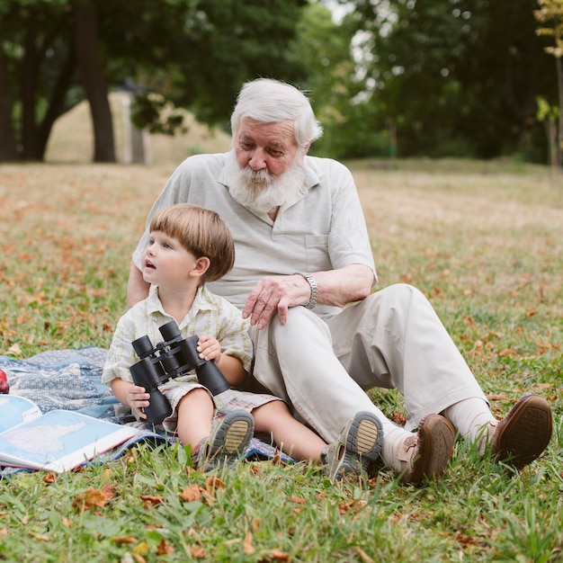Дедушка и внук в парке с биноклем