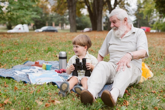 Grandpa and grandson at picnic with binocular