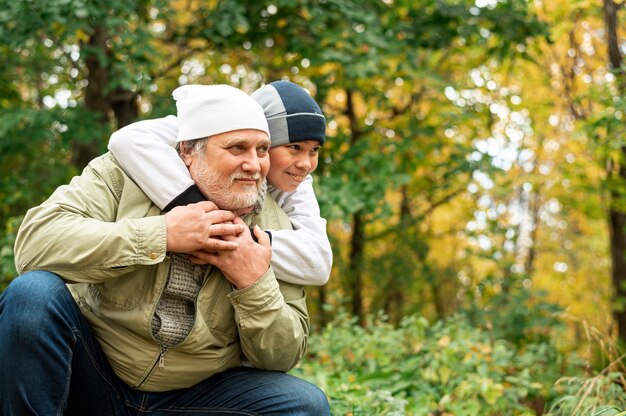 Дедушка с внуком в парке на осень