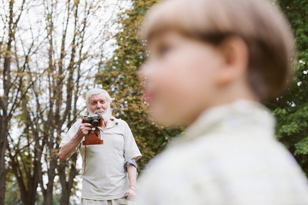 Grandpa with grandson in park taking photos