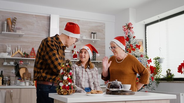 祖父母 子供 母 父と妹が面白い眼鏡とサンタの帽子をかぶってクリスマスプレゼントを開きます プレミアム写真
