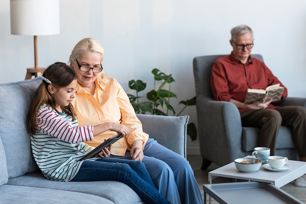 Grandparents and girl with laptop inside