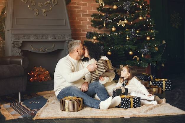 Grandparents sitting with their granddaughter. Celebrating Christmas in a cozy house.