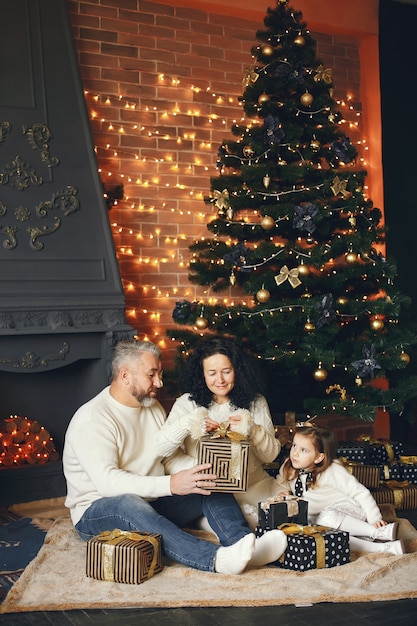 孫娘と一緒に座っている祖父母。居心地の良い家でクリスマスを祝います。