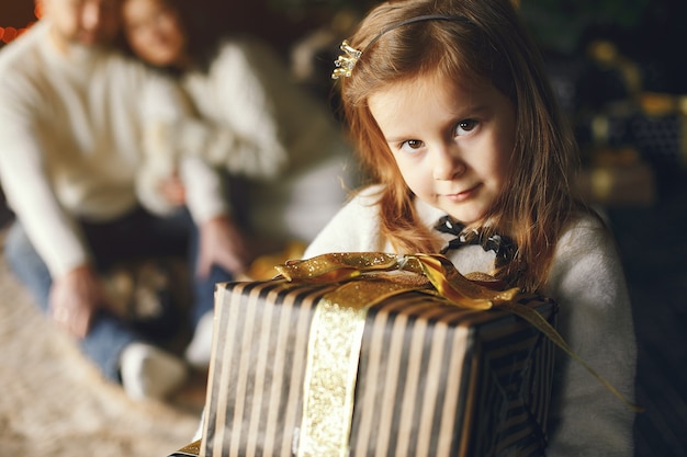 孫娘と一緒に座っている祖父母。居心地の良い家でクリスマスを祝います。