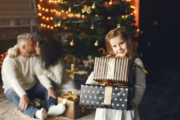 孫娘と一緒に座っている祖父母。居心地の良い家でクリスマスを祝います。