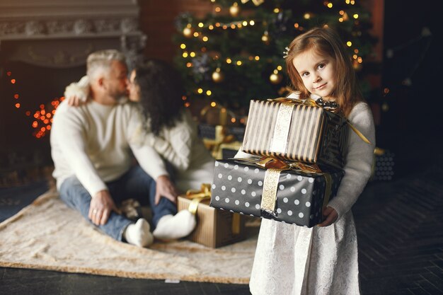 孫娘と一緒に座っている祖父母。居心地の良い家でクリスマスを祝います。