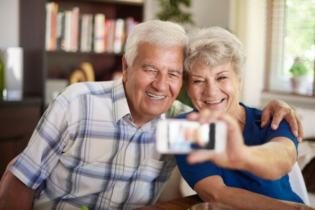 Free photo grandparents taking a selfie with their smartphone