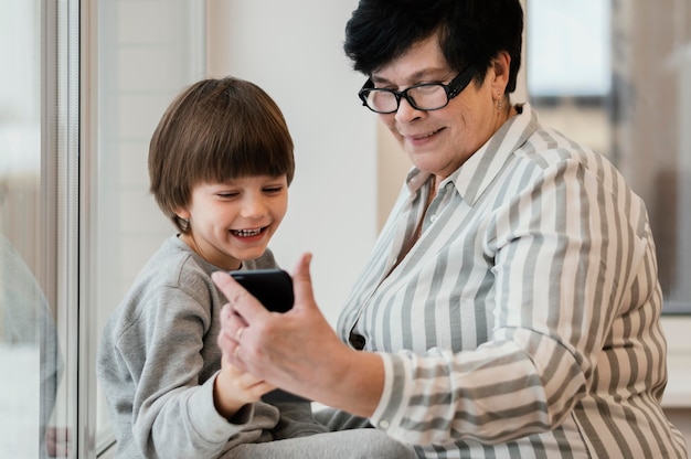 祖母にスマートフォンを見せている孫