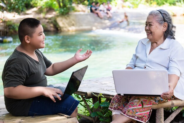 Grandson teaching his elderly female use laptop