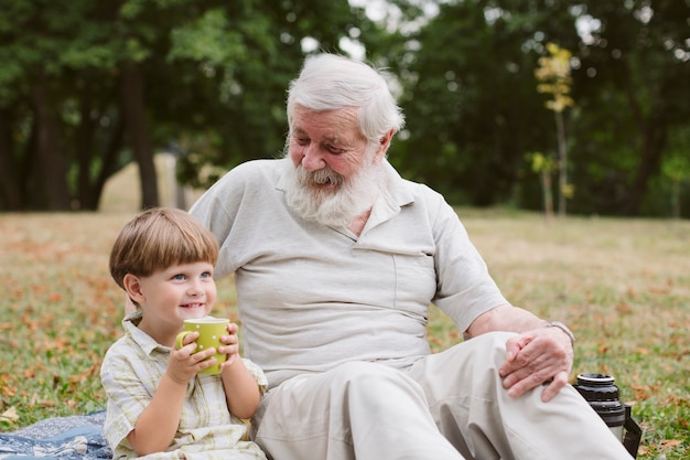 Внук с дедушкой пьют чай