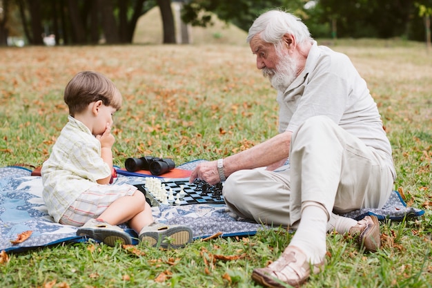 Grandson with grandpa in park at picnic