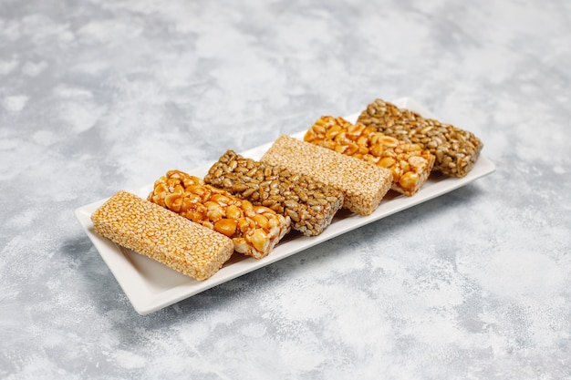 Free photo granola bar. healthy sweet dessert snack. sesame, peanut, sunflower in honey. gozinaki is georgian national food, oriental sweet. top view on concrete